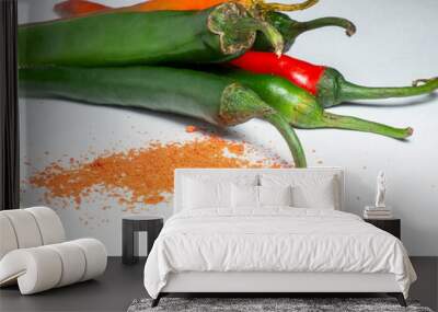 The green pepper and ground red pepper are isolated. Sharp pepper on a white background. Ingredient for a burning dish. Wall mural