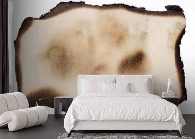 A small piece of yellow aged vintage  paper with burned  black edges. Isolated Wall mural