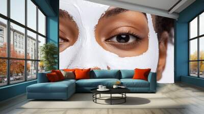 A closeup of a woman's face with a white clay facial mask applied to treat acne, surrounded by soft lighting and a clean white background, perfect for skincare tutorials and beauty products. Wall mural