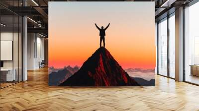 A silhouette of a person standing on a mountain peak with arms raised in victory backlit by a golden sunset The image conveys success achievement and triumph over challenges The background is expansiv Wall mural