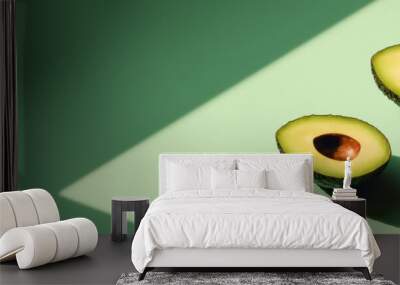 Avocado cut in half on a neo-mint background. Web banner with sunlight. Wall mural