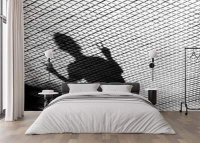 Blurry shadow silhouette of a young man showing V finger sign Wall mural