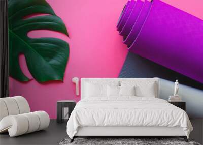 purple yoga mat, water bottle and headphones on a pink background Wall mural