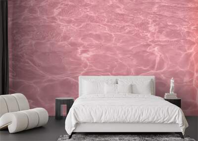 Closeup of calm clear water surface with water splashes in trendy pink color. Swimming pool water texture. Trendy fresh abstract nature background. 2020 color trend concept. Wall mural