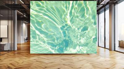 Closeup of mint green transparent clear calm water surface texture with splashes and bubbles. Trendy abstract summer nature background. Mint colored waves in sunlight.  Wall mural