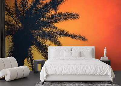 Golden tropical sunset with dark silhouette of coconut palm tree. Trendy vintage toned summer travel background with copy space. Retro style creative design concept. Open composition.  Wall mural