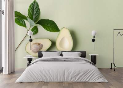 Plant background for demonstration of cosmetics, products. Avocado on a green pastel background Wall mural