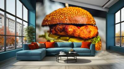 Homemade crispy chicken fillet burger with tomatoes, pickled cucumbers, and bbq souce on dark background Wall mural