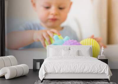 Cute baby boy toddler playing with massage ball. Wall mural