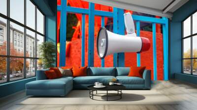 Red and white bullhorn for the public announcement against the background of orange life jackets Wall mural