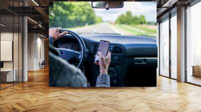 A man use smartphone while driving in the car. Road danger concept Wall mural