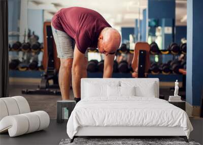 A portrait of senior man doing workout before training in the gym. People, healthcare and lifestyle concept Wall mural