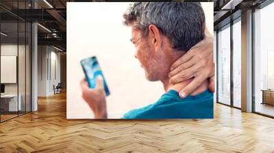 Neck pain using smartphone outdoor. Healthcare, lifestyle and technology concept Wall mural