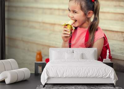 Pupil having a snack sitting on a stairs outdoor. Back to school. Wall mural