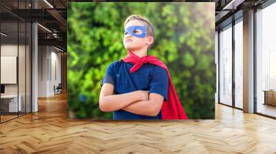 Superhero kid against green background outdoor. Childhood, success and and power concept Wall mural