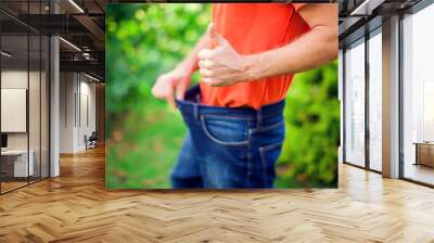 Young man wearing big loose jeans - weight loss concept Wall mural