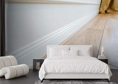 Closeup of a beige hardwood skirting board on wooden floor Wall mural