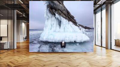 Girl lying on the ice. The girl next to the icy mountain Wall mural