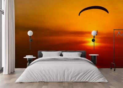 Paraglider silhouette against the background of the sunset sky Wall mural