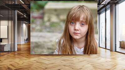 Portrait of sad vulnerable little girl in dirty alley, shallow depth of field. Wall mural