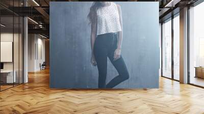 fashionable young girl standing on a gray background textured wa Wall mural