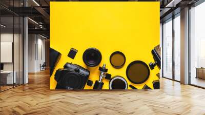 Digital camera, lenses and equipment of the photographer on a yellow background Wall mural