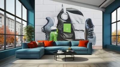 Green backpack with sportswear and sneakers. The concept of fitness or running Wall mural