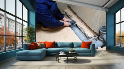 Plumber assemble pvc sewage pipes. Wall mural