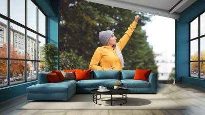 Victory. Profile of young woman with arm up to sky, girl celebrates his success. Outdoors daylight Wall mural