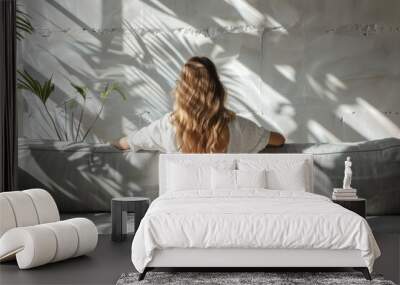 A woman sits on a couch in a room Wall mural