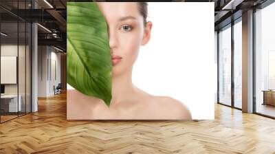 Beautiful young woman with clean perfect skin. Beauty portrait. Spa, skin care and wellness. Fresh green leaf. Wall mural