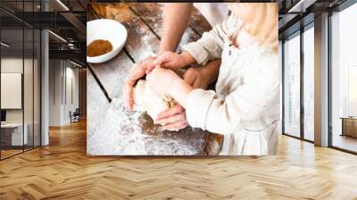 Cute little girl and her beautiful mom make dough in a bowl stay at home. Wall mural