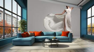 Fashion woman portrait in white long flying airy dress Wall mural