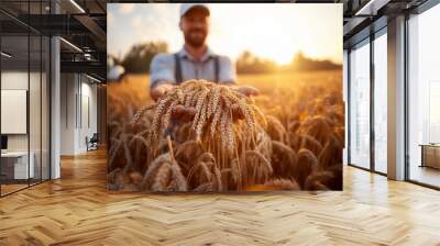 Holding a handful of golden wheat, a farmer stands in a wheat field extending into the distance, with a white background emphasizing the fruitful harvest.
 Wall mural