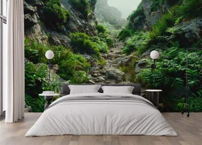 Lush green plants surround a narrow rocky path Wall mural