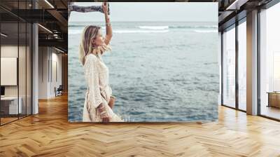 Boho model wearing dress and straw hat on the beach Wall mural