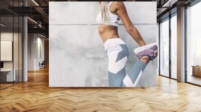 Fitness sport model in fashion sportswear posing over gray wall Wall mural