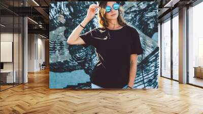 Model wearing plain tshirt and sunglasses posing over street wall Wall mural