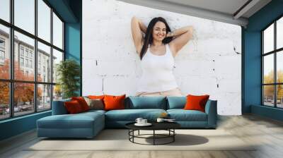 Plus size model dressed in white shirt posing over brick wall Wall mural