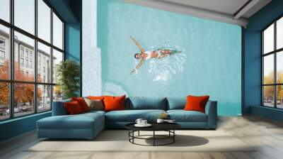 Woman relaxing in clear pool water in hot sunny day on Bali villa Wall mural