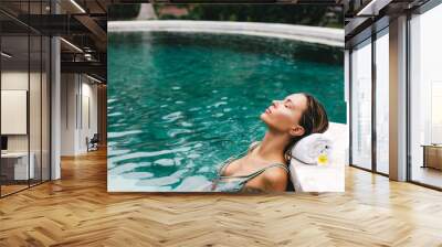 Woman relaxing in swimming pool Wall mural