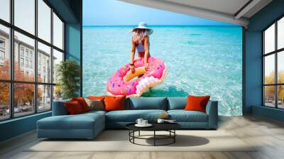 Woman with inflatable ring on beach Wall mural