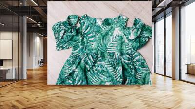 A green dress with a palm leaf pattern for toddlers, beautifully designed for a stylish and comfortable summer outfit. Wall mural