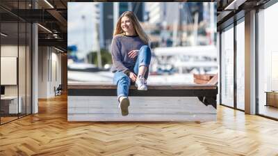 outdoor portrait of young happy smiling teen girl on marine background on a sunny day, auckland central wharf, new zealand Wall mural