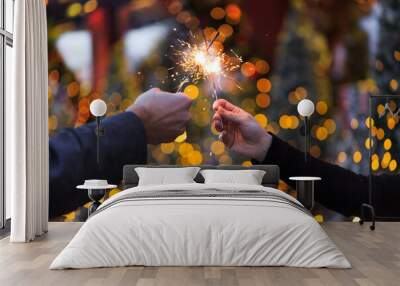 Two hands with sparklers on a Christmas or New Year's eve background Wall mural