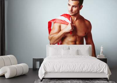 Portrait of handsome young man with stylish haircut in swinwear posing with American flag over gray background. Perfect hair & skin. Close up. Studio shot Wall mural