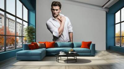 Portrait of young and handsome model in a white shirt. Studio shot. Copy space. Wall mural