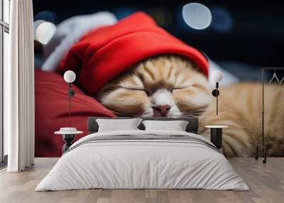 A cute red cat in a Santa hat sleeps on the bed. Christmas card, calendar, pet Wall mural