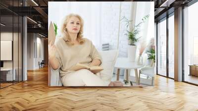 A middle-aged woman woman feels bad because of menopause. She needs support. Hot flashes, sweating, dizziness, irritability. Menopause concept. Harmonious restructuring of the body. Wall mural