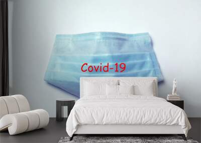 blue medical protective mask on a gray background with inscription Covid-19, concept accessory for coronavirus protection Wall mural